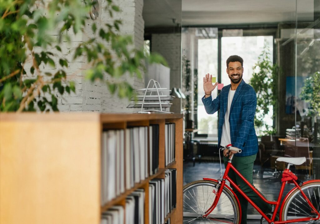 Young multiracial man with bicyckle in office.